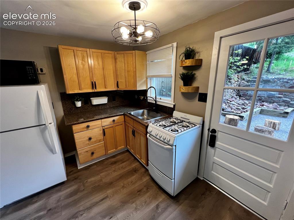 Image 25 of 45: Upper Apt: Nice kitchen with gas stove. View to rear patio with fire pit