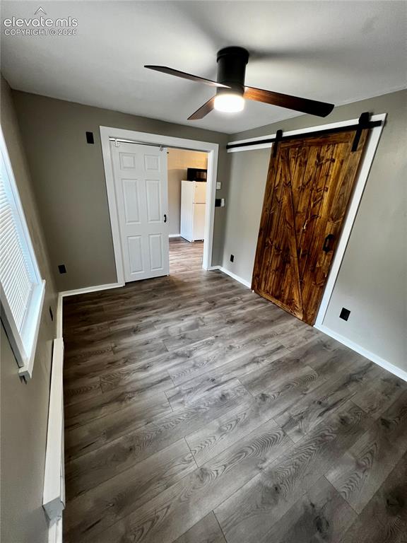 Image 26 of 45: Upper Apt: View of bedroom towards living room. Dual sliding barn doors