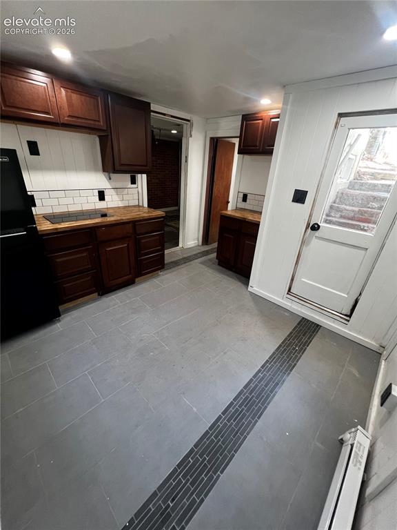 Image 29 of 45: Lower Apt: Exterior door leads to stairs. Shared water heater with upper ap