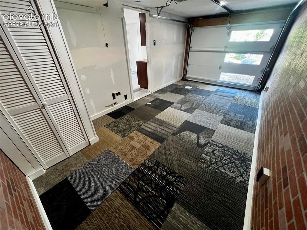 Image 33 of 45: Lower Apt: View of heated garage and/or bedroom/LR. New garage door.
