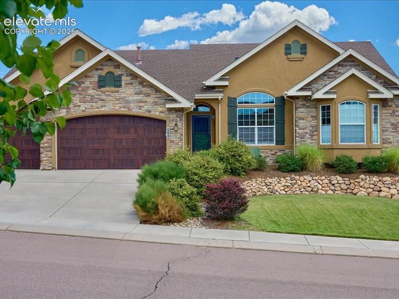 Caption: Stucco and stone exterior with arched architectural details and multiple windows featuring dark shut