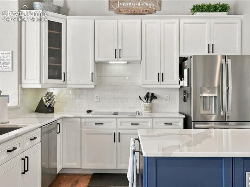 Image 12 of 50: Contemporary kitchen featuring white shaker cabinetry with black hardware, 