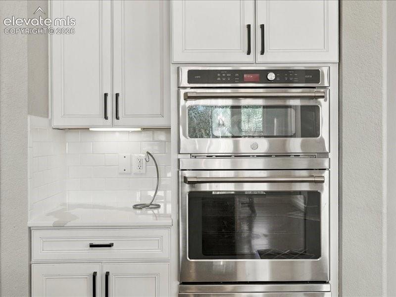 Image 15 of 50: Modern kitchen featuring stainless steel double wall ovens with convection 