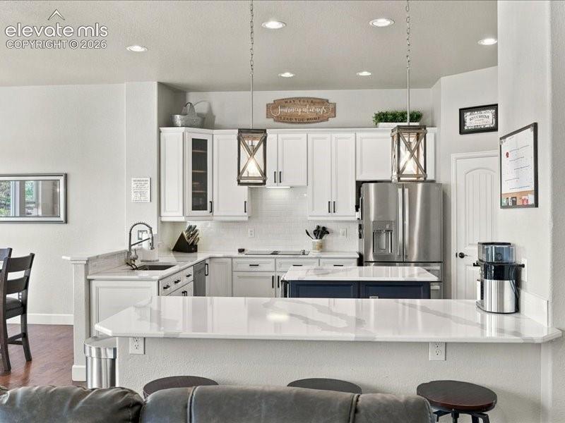 Image 16 of 50: White shaker cabinetry, stainless steel appliances, white subway tile backs