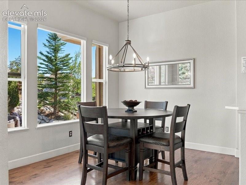 Image 18 of 50: Dining area bathed in natural light through expansive multi-pane windows fr