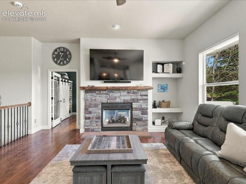 Image 21 of 50: Stone-faced fireplace with a wood mantel