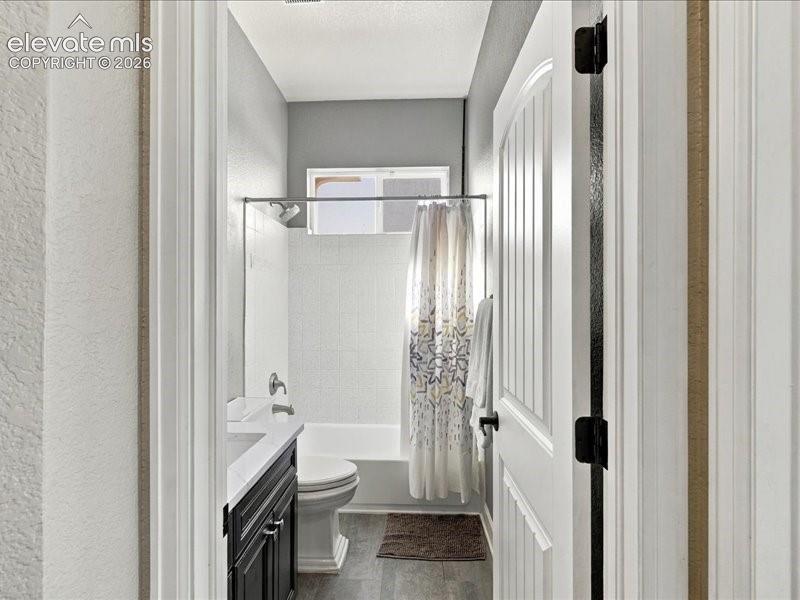 Image 31 of 50: Bathroom featuring a white bathtub, wall-mounted showerhead, and a dark woo
