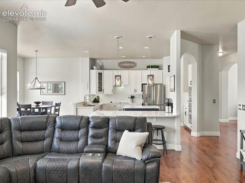 Image 33 of 50: Open-concept living area with wood-finish flooring, recessed lighting, and 