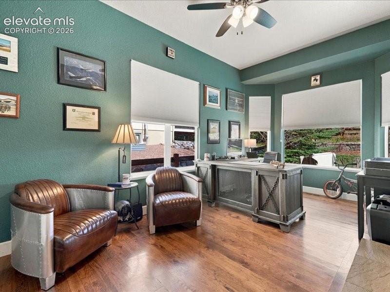 Image 34 of 50: Hardwood-finish flooring, multiple windows with roller shades, and a ceilin