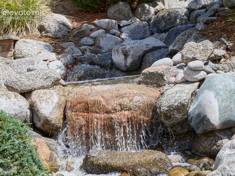 Image 41 of 50: Natural rock water feature with cascading water and varied stone elements