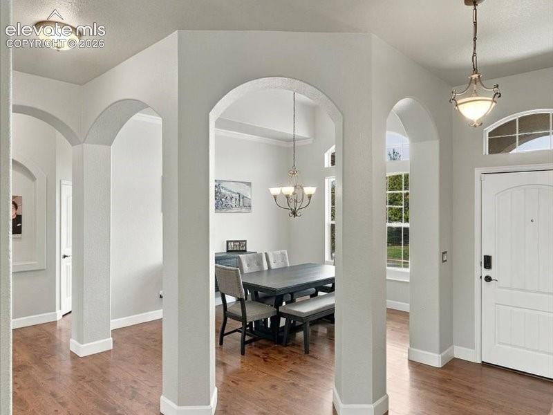 Image 5 of 50: Arched entryways, wood-finish flooring, recessed lighting, decorative chand