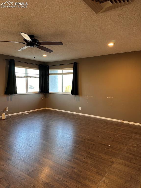 Image 10 of 23: Unfurnished living room featuring dark wood-style floors and a ceiling fan