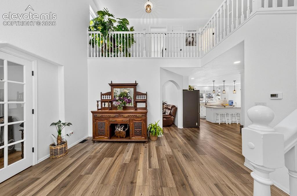 Image 8 of 50: Open foyer leads to the office through the french doors on the left, and th