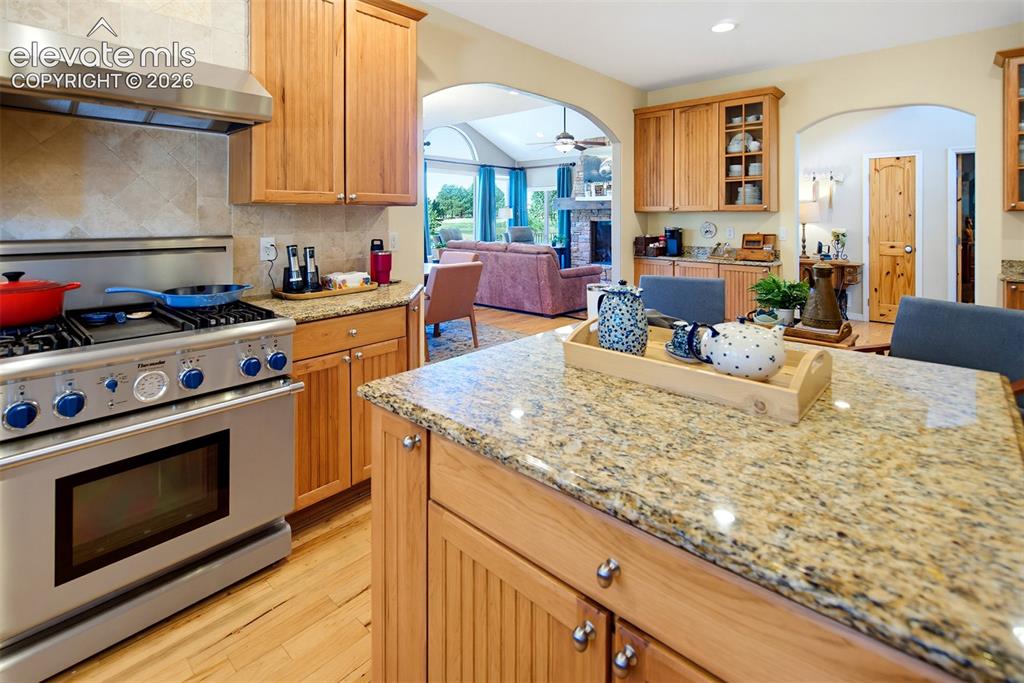 Image 14 of 49: Kitchen features beautiful wood-finish cabinetry, stone countertops, and a