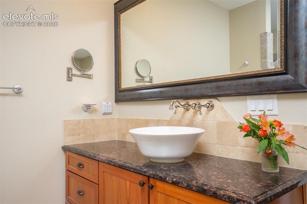 Image 18 of 50: Notice the beautiful granite, table top sink, and framed mirrors