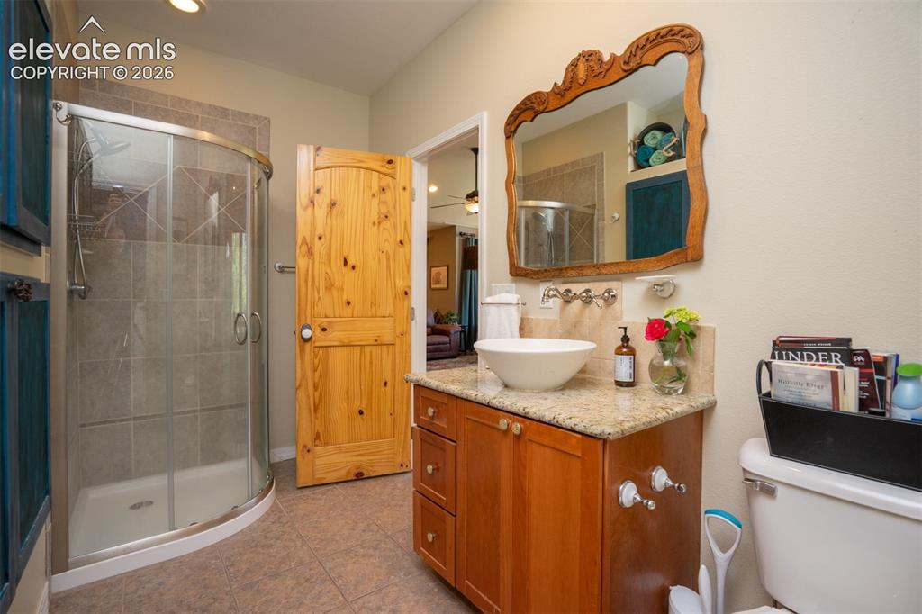 Image 25 of 50: The hall bat offers a glass shower, raised sink, and great cabinet space, a