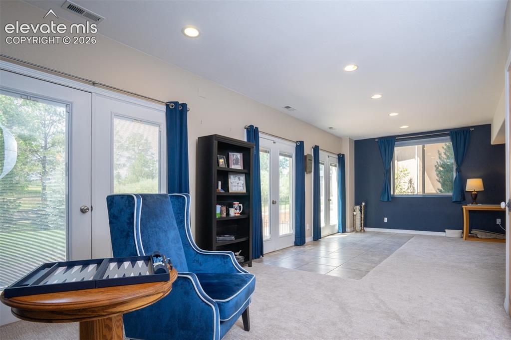 Image 28 of 49: 3 large walk-out patio doors spill light into the basement & help keep the