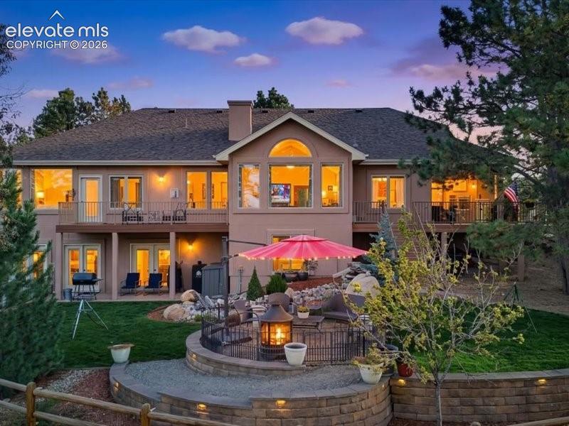 Image 3 of 49: The back of the home shows the multiple windows plus multiple decks & patio
