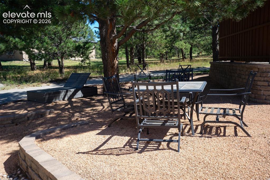 Image 42 of 50: Another patio area is between the main house and the detached garage with g