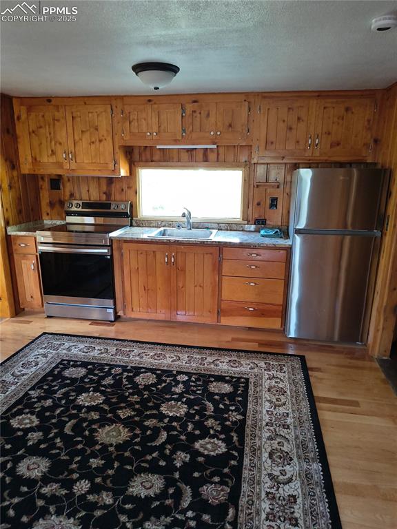 Image 14 of 20: Kitchen featuring appliances with stainless steel finishes, light wood-type