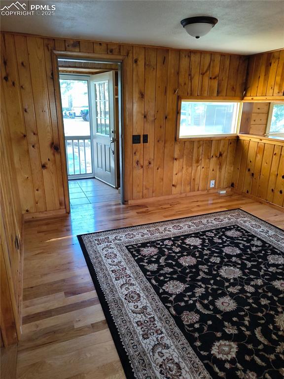Image 9 of 20: Foyer featuring wood walls, light wood-style floors, and a textured ceiling