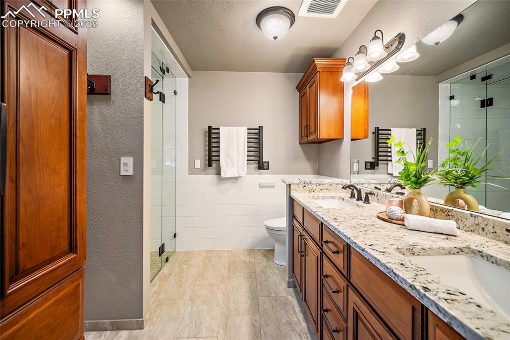Image 21 of 49: Double vanity with heated floors and heated towel rack