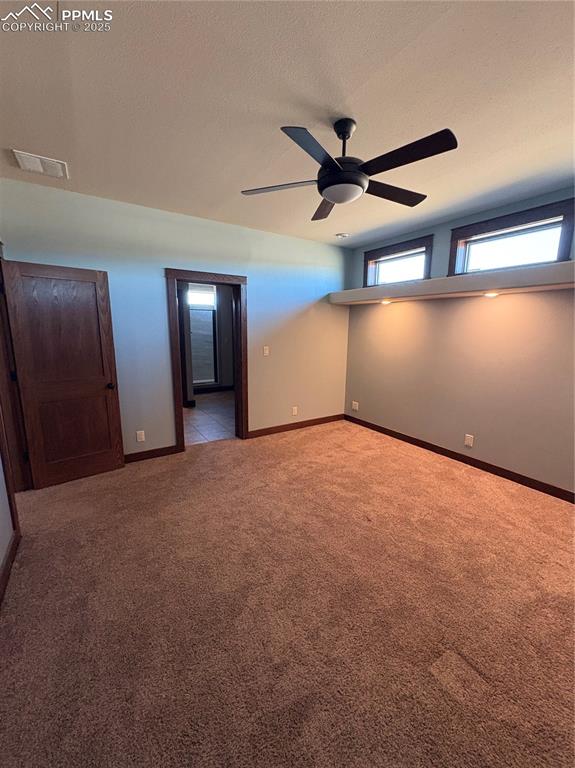 Image 11 of 32: Unfurnished bedroom with light carpet, a textured ceiling, and ceiling fan