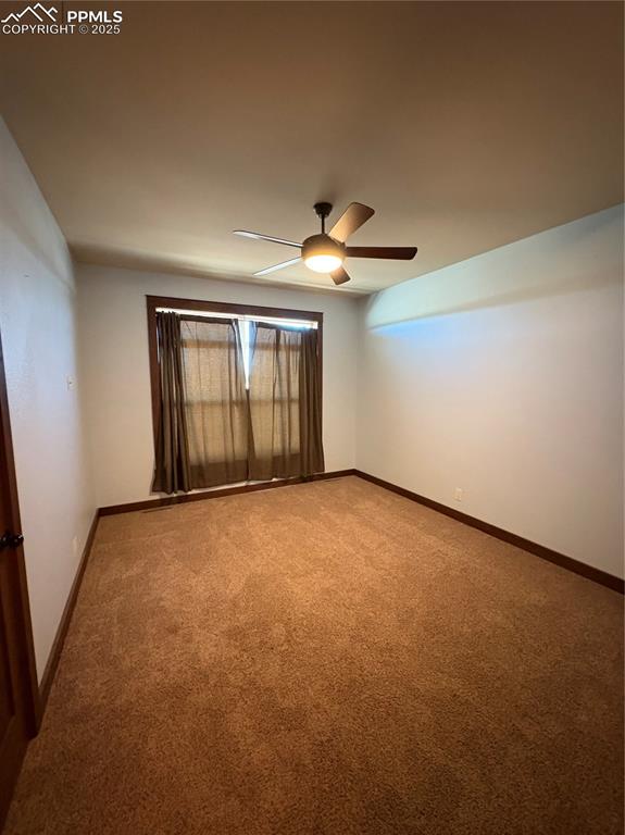 Image 15 of 32: Unfurnished room with carpet and a ceiling fan