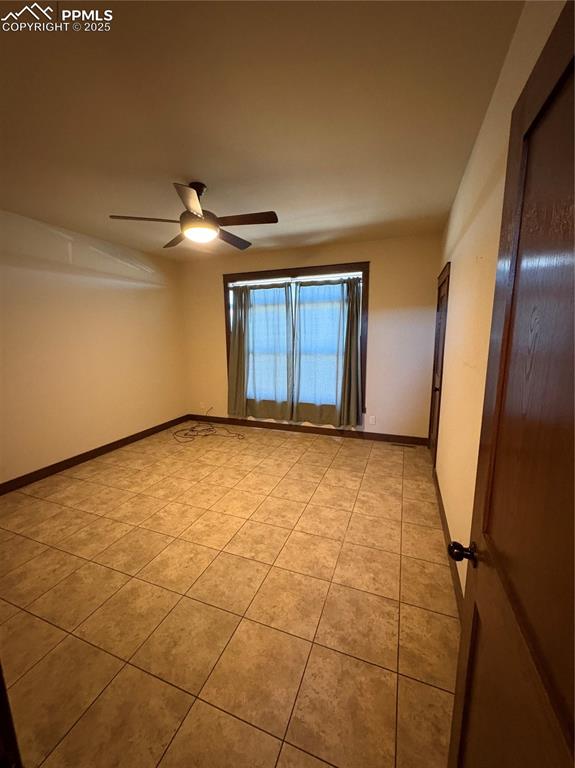 Image 17 of 32: Unfurnished room with light tile patterned floors and ceiling fan