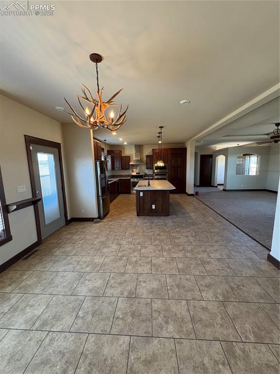 Image 21 of 32: Kitchen featuring open floor plan, light countertops, dark brown cabinets, 