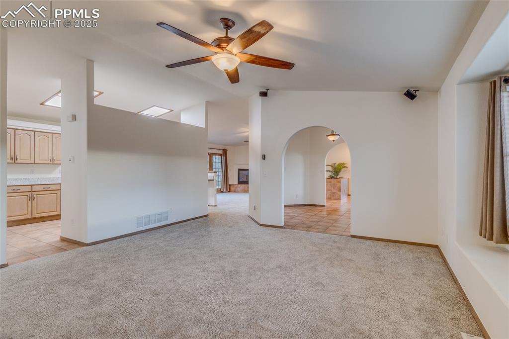 Image 16 of 48: Living room with dining room to the right and kitchen on the left