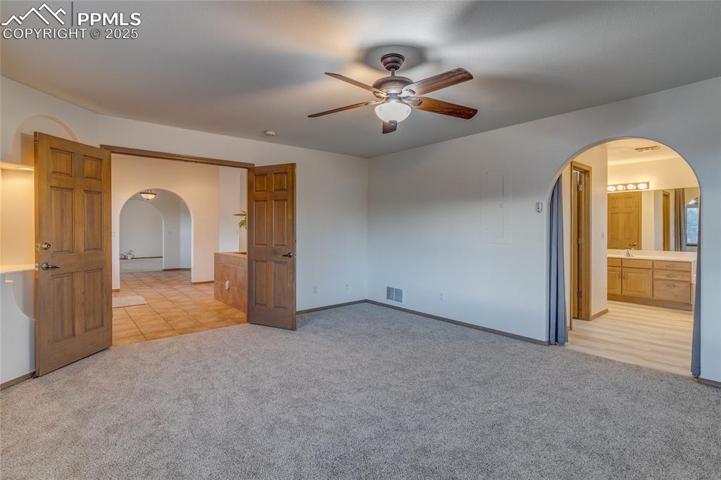 Image 22 of 48: Primary bedroom with primary bathroom to the right. 