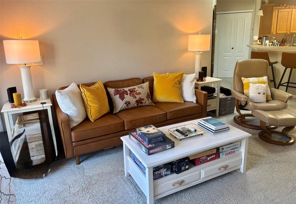 Image 16 of 24: Living room featuring light carpet and a textured wall
