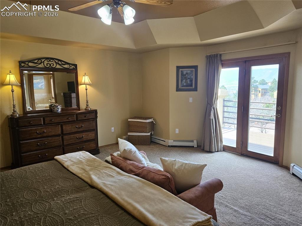 Image 18 of 39: Primary bedroom with tray ceiling and private deck.