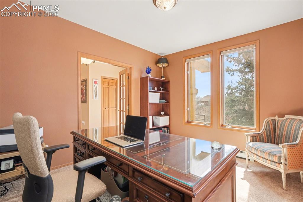 Image 8 of 39: Office space with glass French doors on either side and double windows