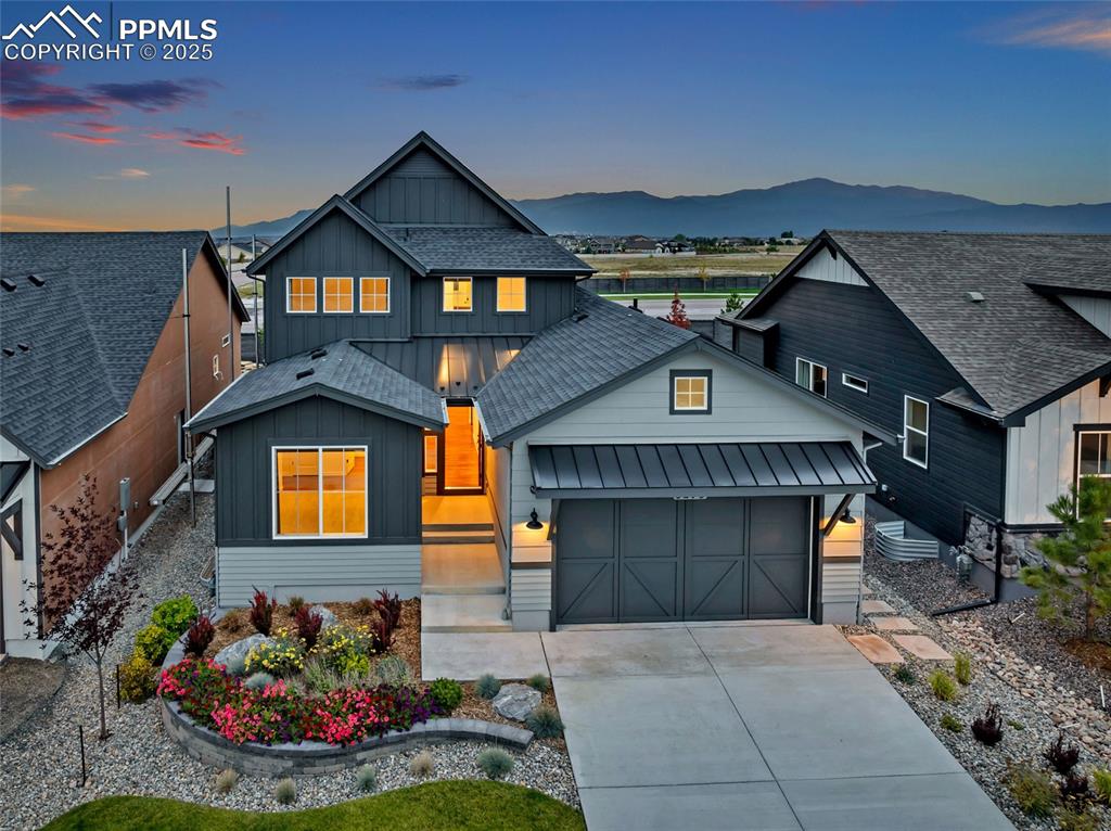 Image 2 of 47: View of front of home featuring board and batten siding, a garage, driveway