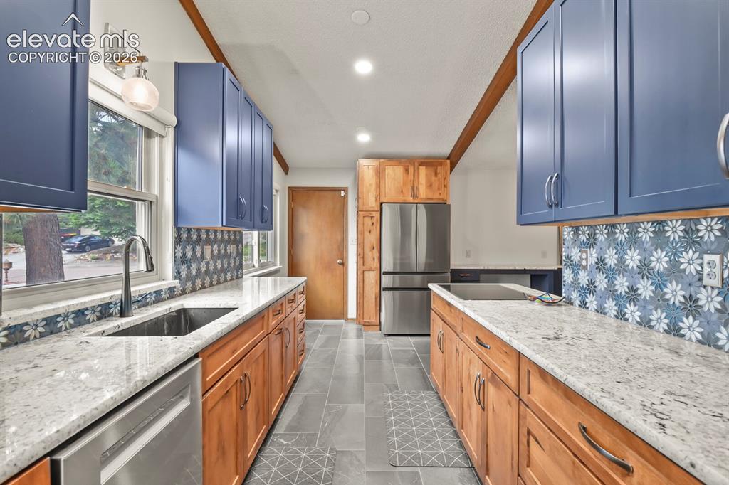 Image 12 of 50: Spacious kitchen featuring two-tone cabinetry, light-toned countertops, a s
