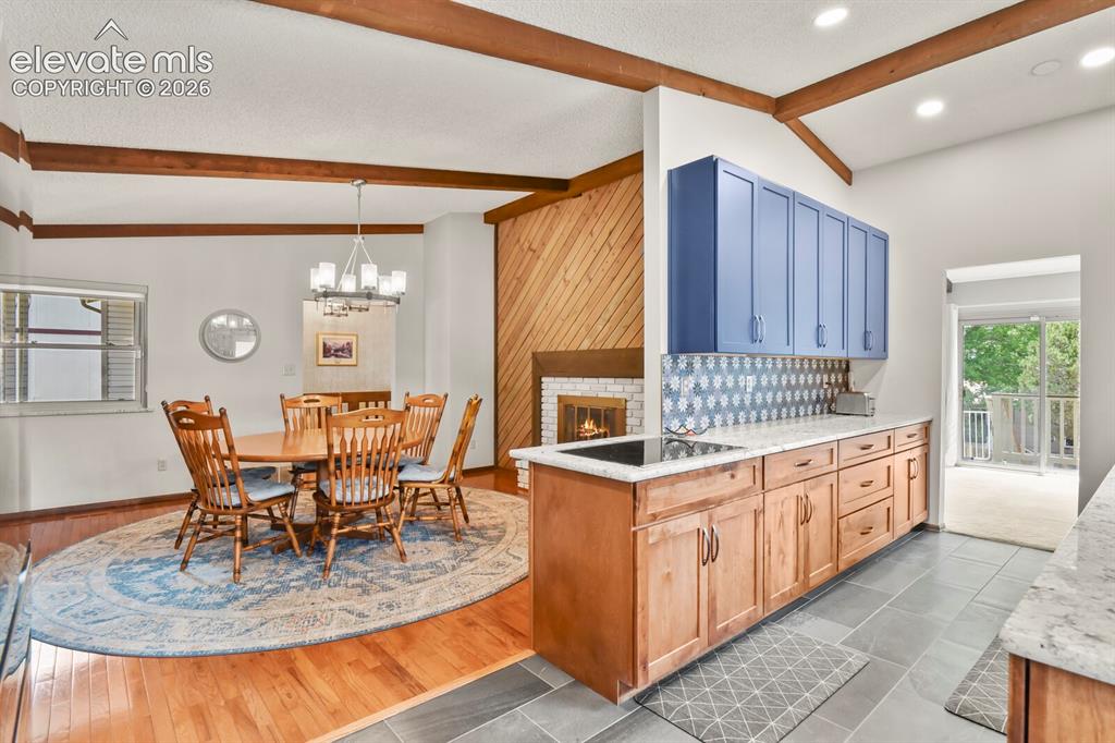 Image 14 of 50: Open-concept living space featuring wood-finish flooring, exposed ceiling b