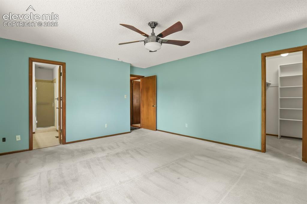 Image 19 of 50: Carpeted room featuring a ceiling fan with integrated lighting, two wood-fi