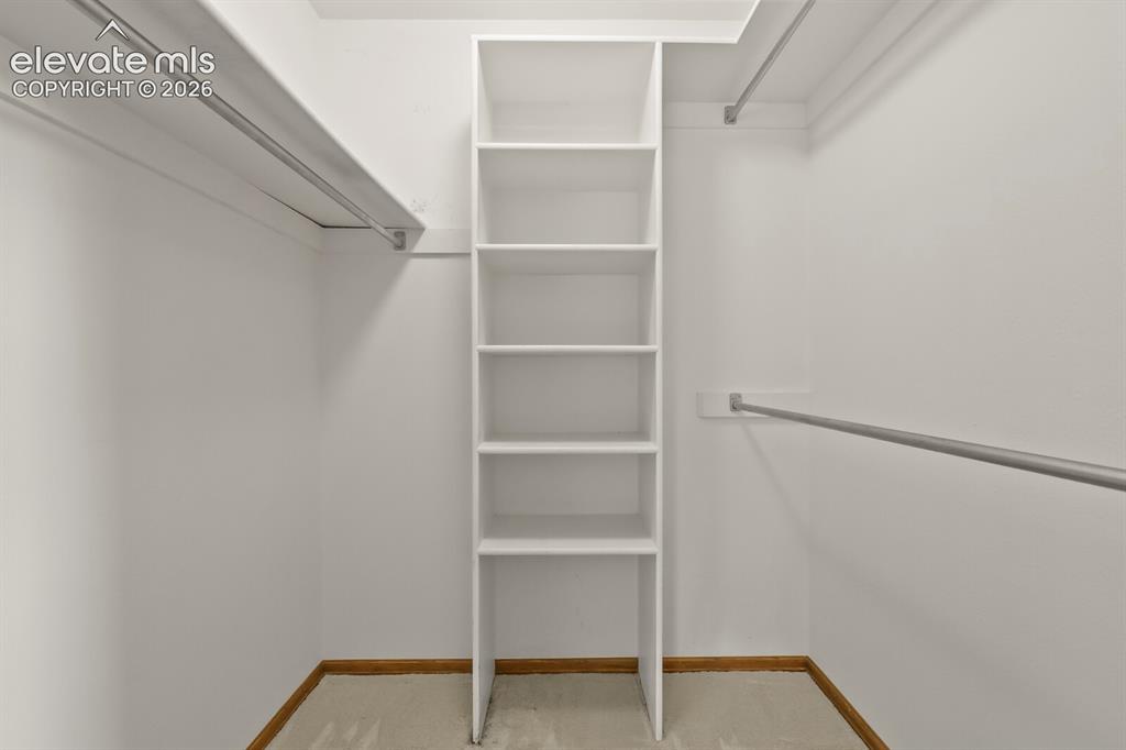 Image 20 of 50: Closet featuring built-in shelving, multiple hanging rods, and light-toned