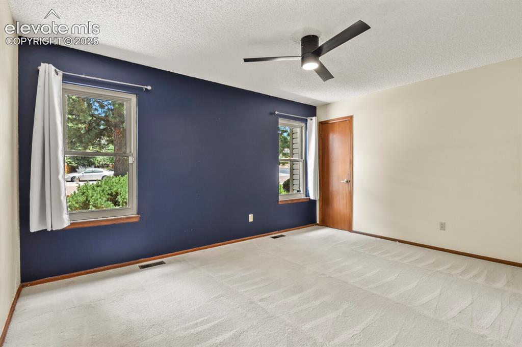 Image 22 of 50: Room featuring two windows with wood sills, a dark accent wall, and light-c
