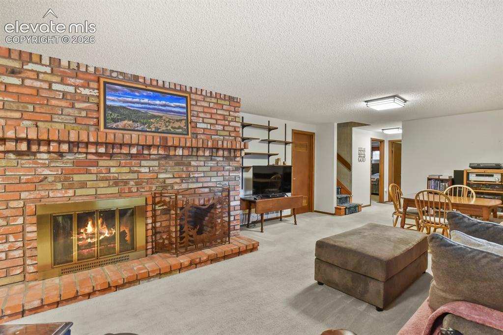 Image 27 of 50: Brick fireplace with a brass firebox surround and hearth, featuring built-i