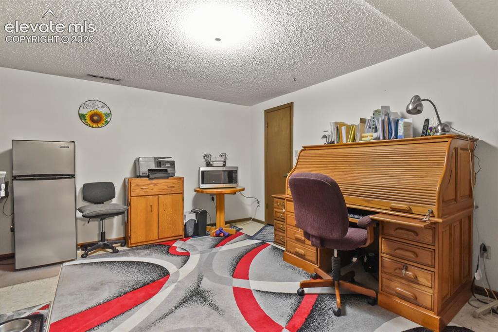 Image 29 of 50: Spacious room with white walls and textured ceiling