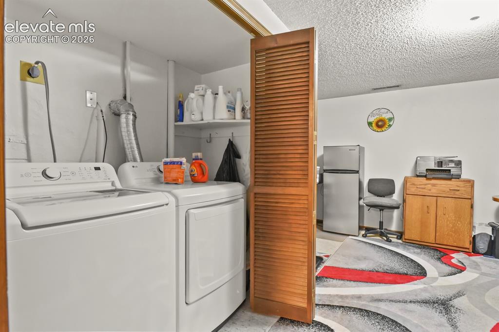 Image 30 of 50: Dedicated laundry area featuring the included white top-load washing machin