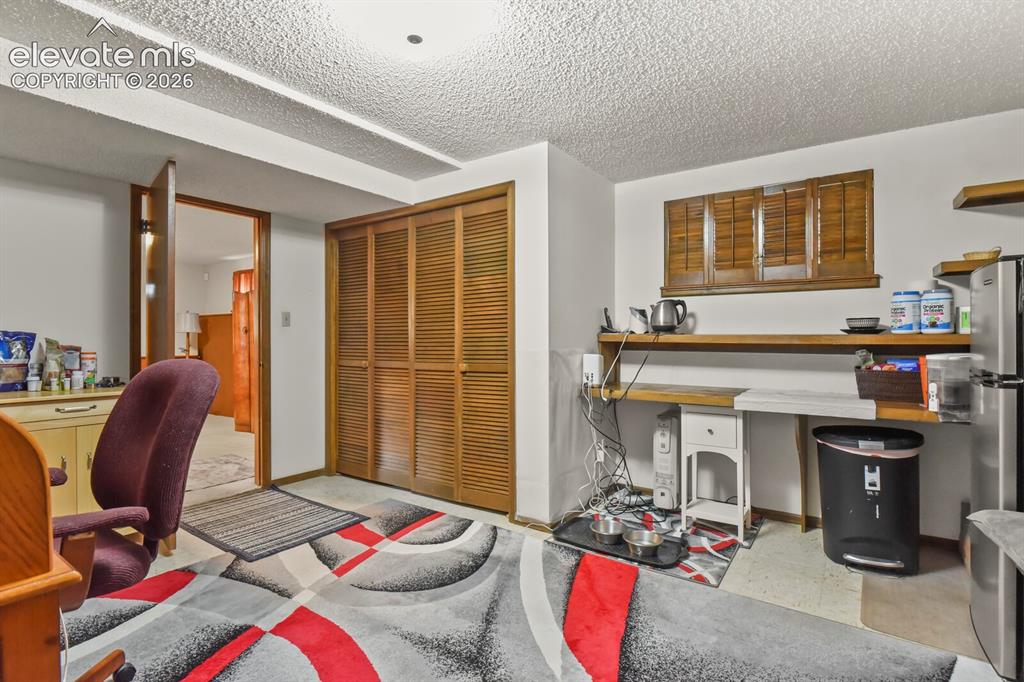 Image 31 of 50: Room featuring wood-finish bi-fold louvered closet doors, a built-in shelvi