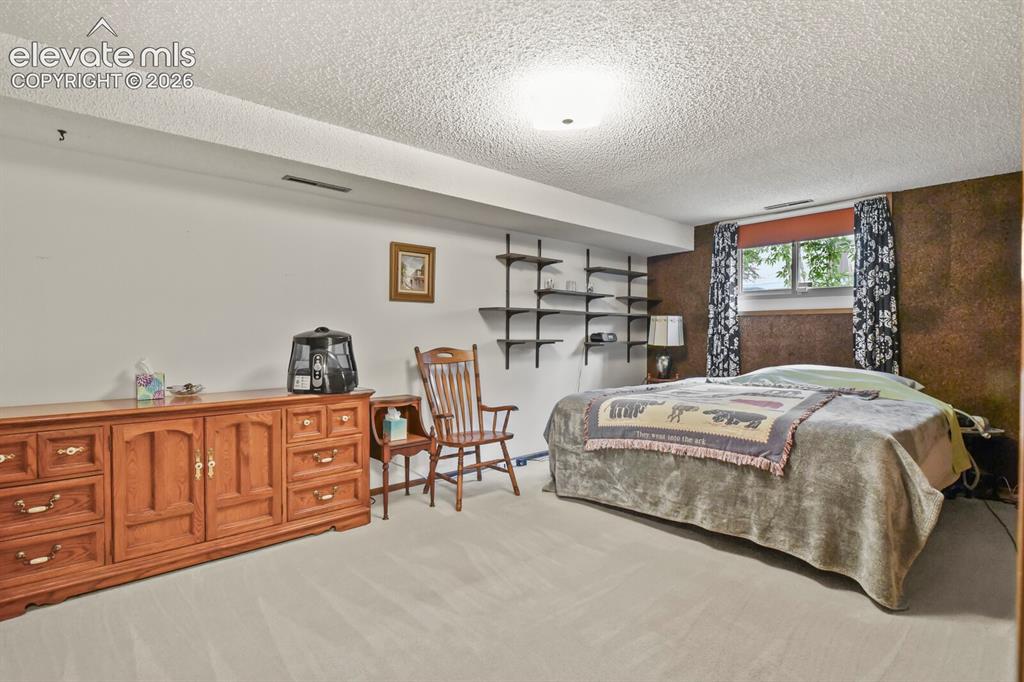 Image 32 of 50: Spacious room featuring light-colored carpeting and a window with exterior