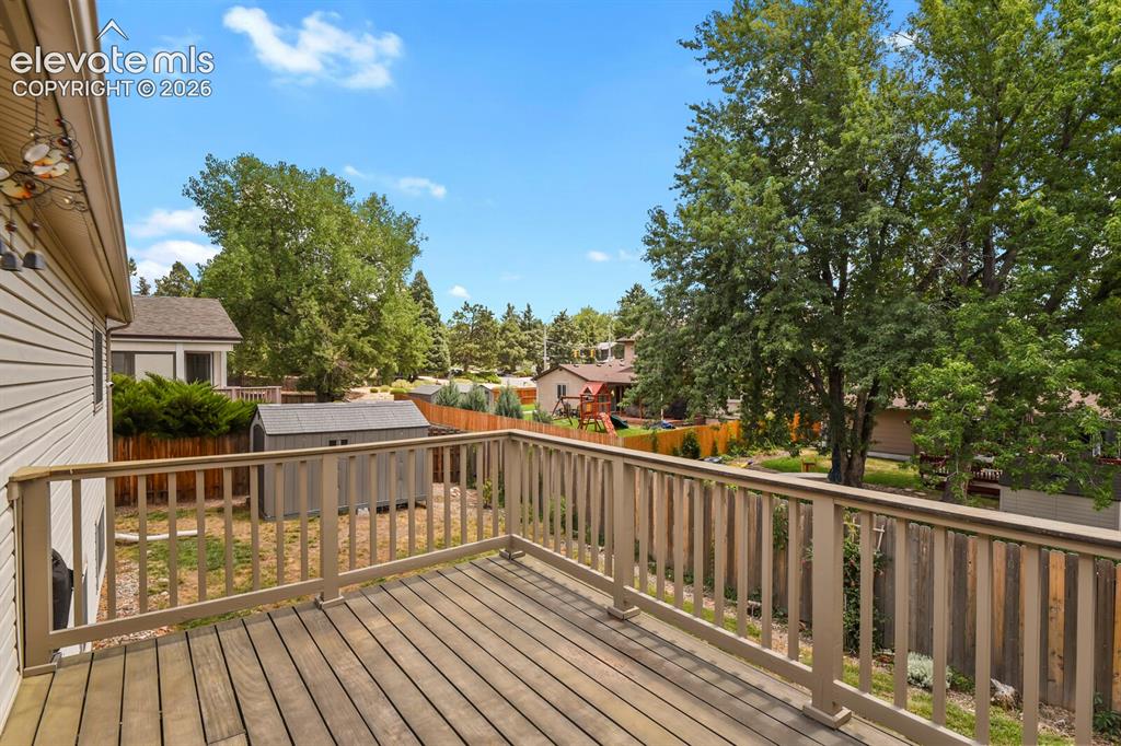 Image 39 of 50: Exterior wood deck with a slatted railing, offering an elevated perspective