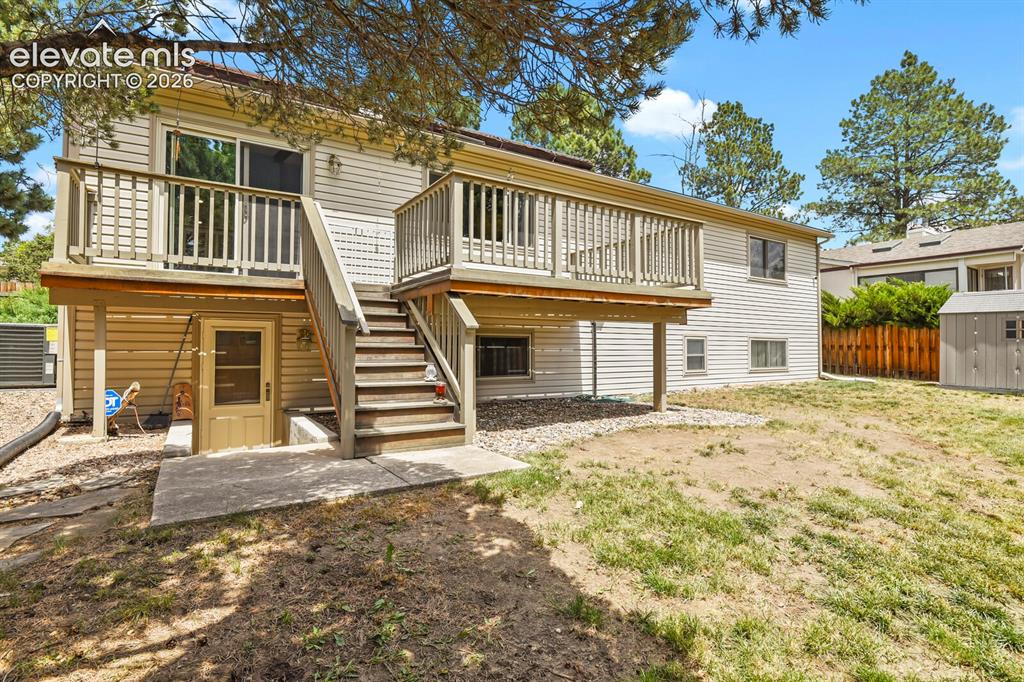 Image 40 of 50: Rear exterior featuring a two-story design with siding, an upper-level deck