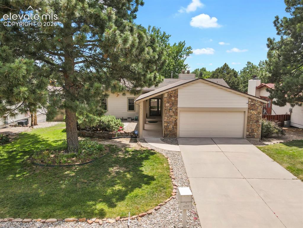 Image 42 of 50: Front exterior featuring a concrete driveway, attached two-car garage, ston