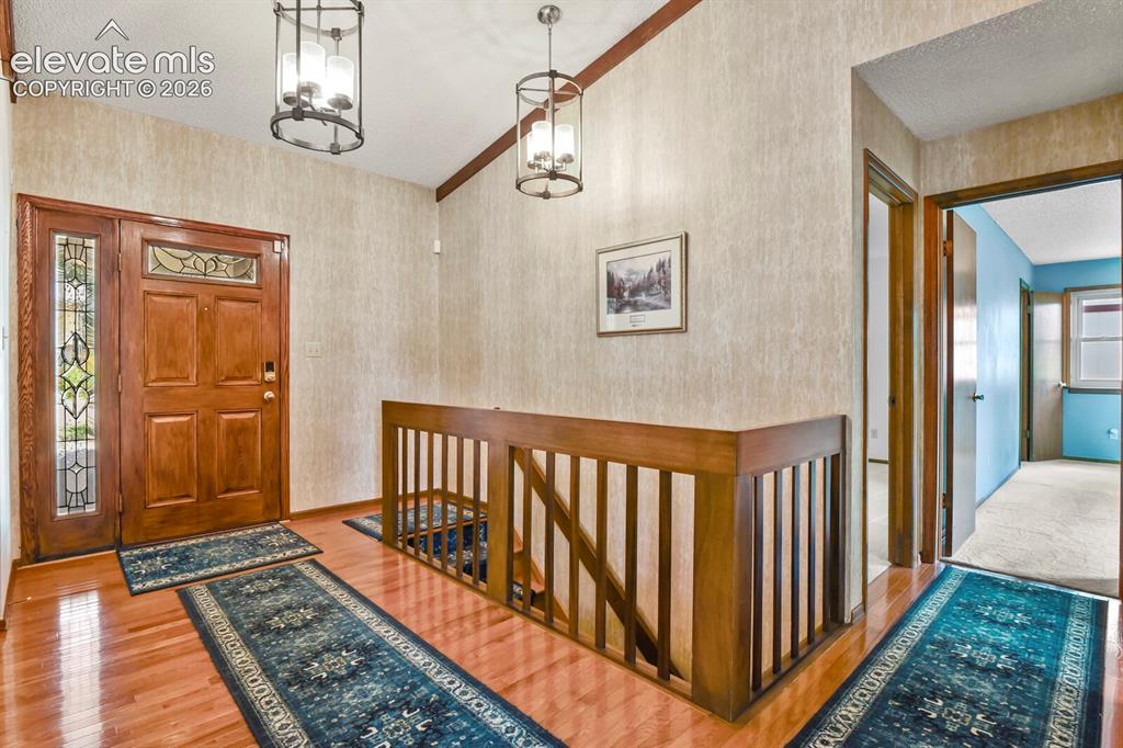 Image 5 of 50: Entryway featuring wood-finish flooring, a solid wood front door